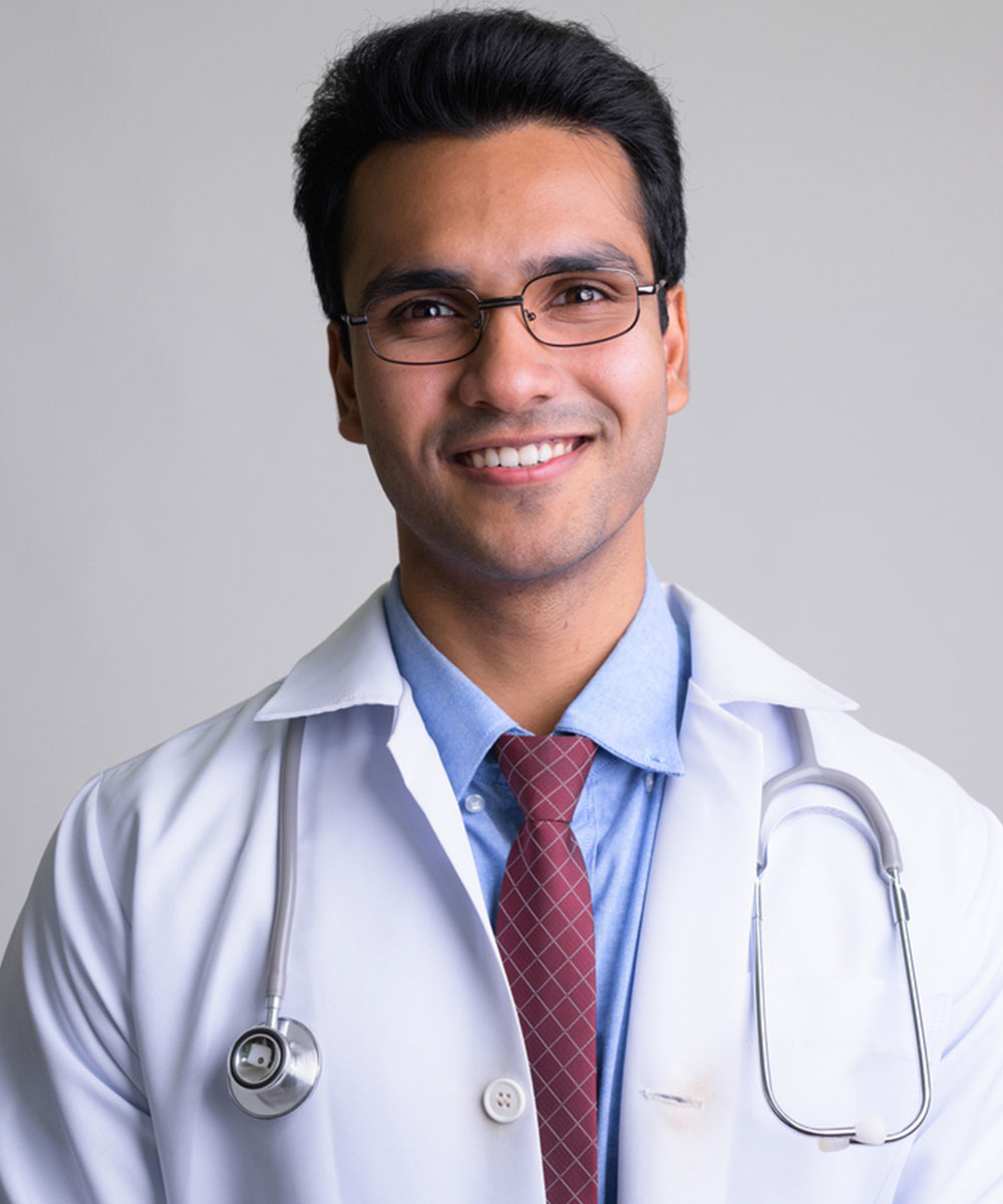 a man wearing glasses and smiling at the camera